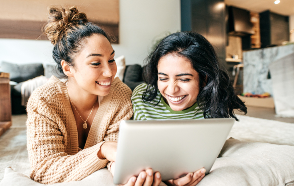 Two teenage women looking at a tablet device