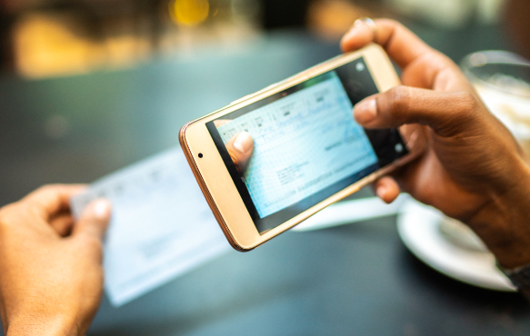 A person using a mobile phone to deposit a check